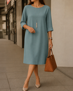 Linnea midi dress in wine red, styled with simple accessories for a polished yet relaxed look that flatters.