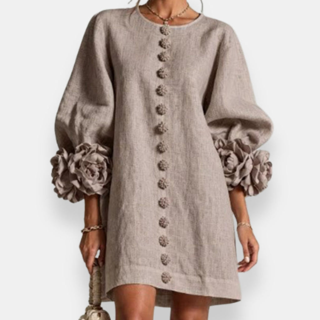 The embossed floral dress in black, presented on a hanger to showcase its complete design and fabric quality.
