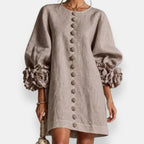 The embossed floral dress in black, presented on a hanger to showcase its complete design and fabric quality.