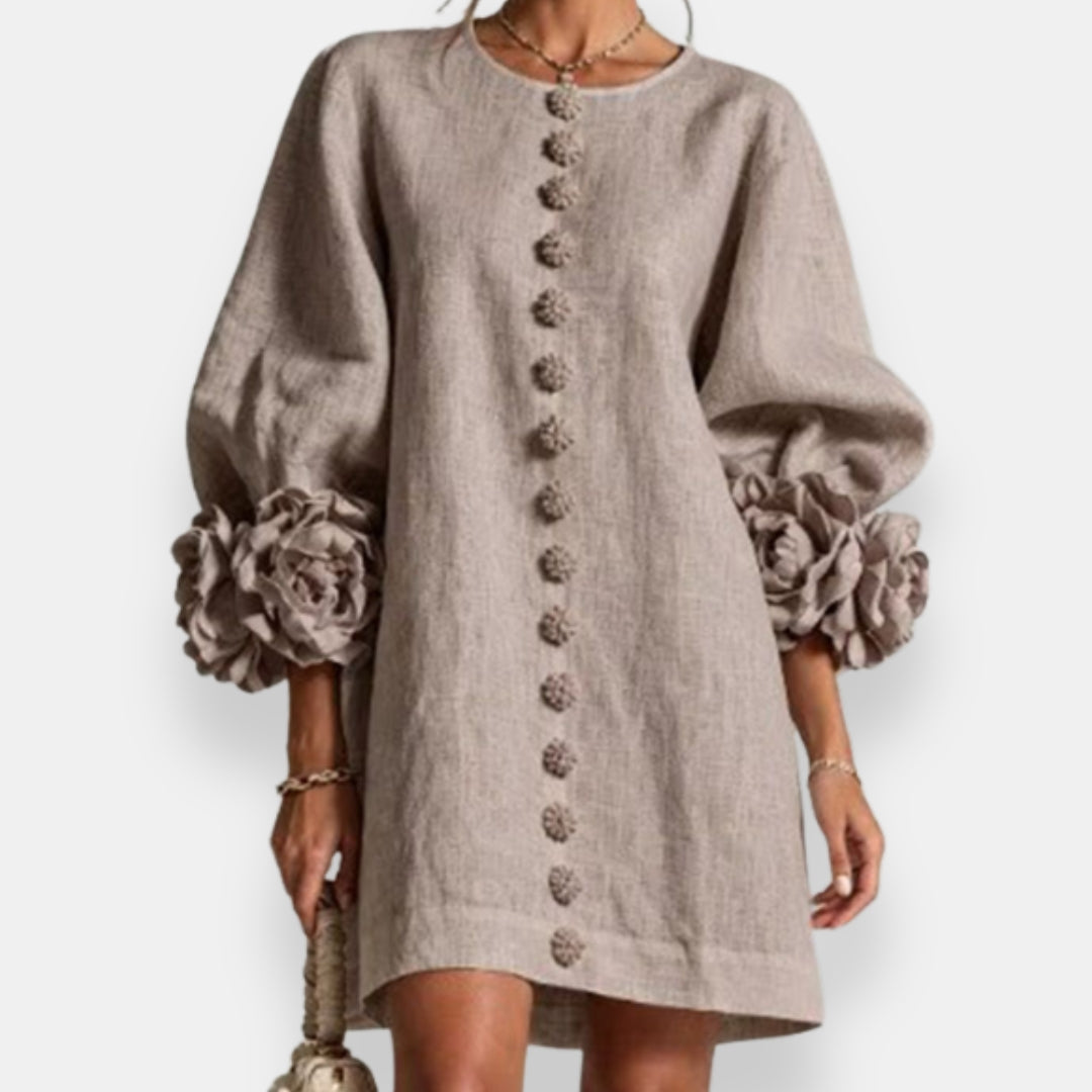 The embossed floral dress in black, presented on a hanger to showcase its complete design and fabric quality.