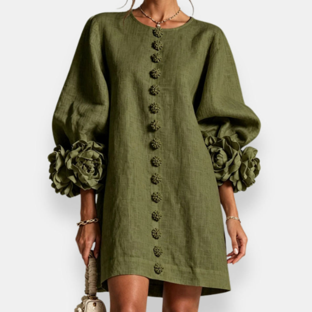 A vibrant apricot embossed floral dress worn by a model, captured in a relaxed pose perfect for warm weather.