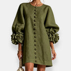 A vibrant apricot embossed floral dress worn by a model, captured in a relaxed pose perfect for warm weather.