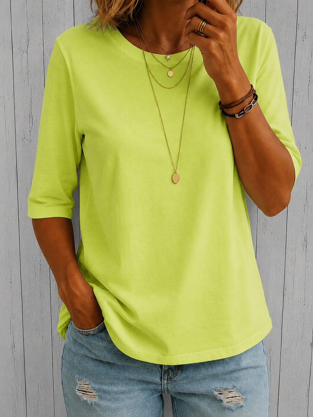 Folded green relaxed half-sleeve t-shirt on a neutral background, highlighting its soft feel.