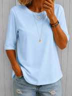 Side profile of a woman in a white relaxed half-sleeve t-shirt, showing the flattering, easy fit.