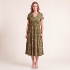 Side profile of the woman wearing the floral twist dress, highlighting the flow of the skirt and the practical side seam pockets.