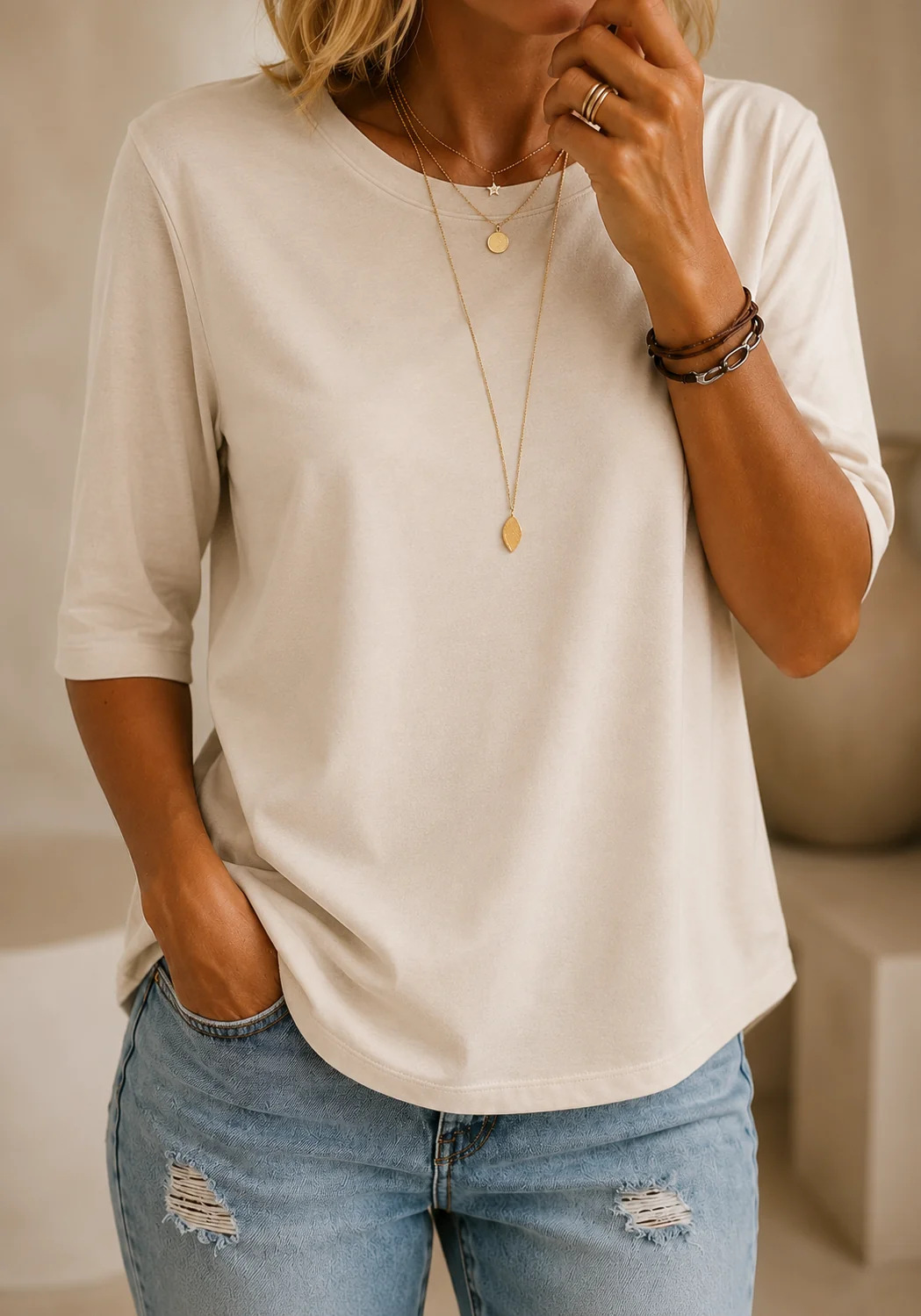 Woman layering the red relaxed half-sleeve t-shirt under an open jacket for a chic look.