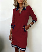 A woman standing confidently in the red long sleeve dress, ready for a casual day.