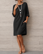 Model wearing the elegant Linnea midi dress in off-white, showcasing its relaxed, flattering fit.