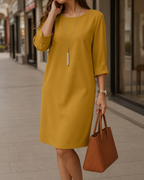 Woman walking outdoors wearing the casual Linnea dress in khaki, ideal for a comfortable and stylish day out.