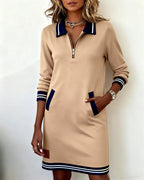 A model sitting comfortably in the long sleeve dress, showcasing its relaxed appeal.